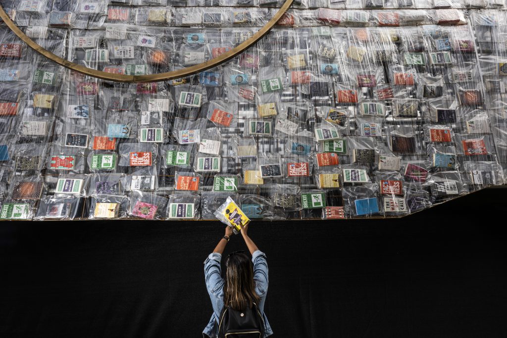 Claire Govender adds the 20,000th book to "Ben Ben Lying Down with Political Books" by Marta Minujin, Photo: Fabio De Paola/PA Wire.